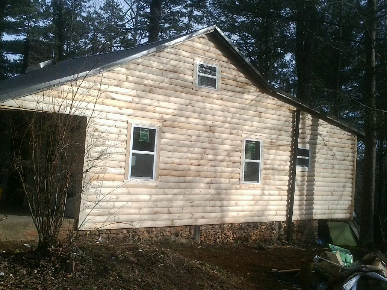 New log siding and dark metal roofing on a gable end in Leesburg